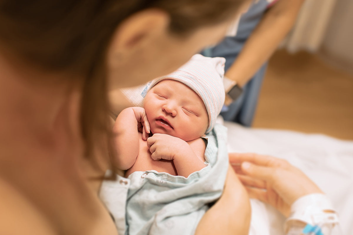 Mutter mit neugeborenen Baby auf dem Arm