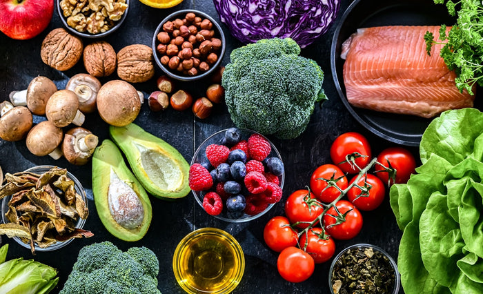 Auf einer schwarzen Steintischplatte liegen verschiedene Lebensmittel reich an Antioxidantien.